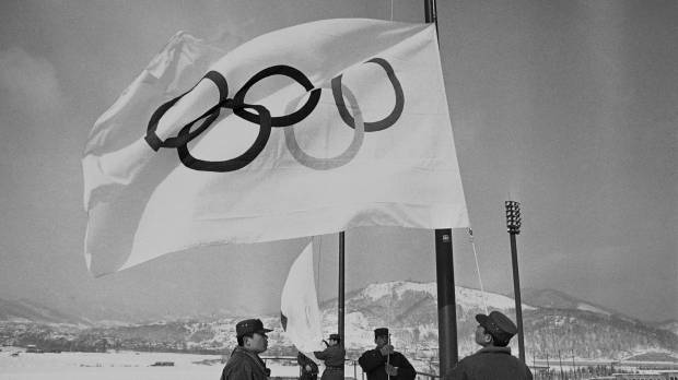 Members of Japan’s Ground Self-Defense Force are seen raising Olympic flags in Sapporo in a file photo taken Jan. 23, 1972, before the opening of the 1972 Winter Games. Sapporo Olympic bid chiefs remain vague over target year