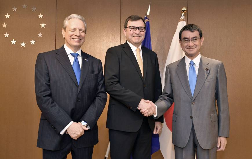 Petr Jezek, chair of the European Parliament Delegation for Relations with Japan (center), shakes hands with Foreign Minister Taro Kono (right) and European Union Ambassador Viorel Isticioaia-Budura during a reception to celebrate Europe Day in Tokyo on May 10.