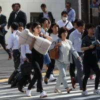 Commuters are seen in the Shinjuku district of Tokyo in May. Many Japanese companies are starting one-day internship programs to help job-hunting university students amid an ongoing labor shortage. Many Japanese firms turning to one-day internships to secure new grads