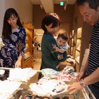 A couple shop with their daughter-in-law (left) and grandchild at a Sayegusa Inc. clothing store in Tokyo’s Ginza district. The nation’s savings-rich elderly spend about ¥9.7 trillion a year on their offspring. Cashed-up grannies splurging on grandkids boost Japan's economy