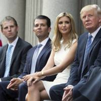 Donald Trump (right) sits with his children (from left) Eric Trump, Donald Trump Jr. and Ivanka Trump during a ground breaking ceremony for the Trump International Hotel in Washington in 2014. New York’s attorney general filed a lawsuit Thursday accusing Trump of illegally using money from his charitable foundation to settle disputes involving his business empire and to burnish his image during his run for the White House. The president blasted the case as politically motivated. New York sues Trump and his charity over 'self-dealing'