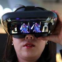 A woman plays the game “Star Wars: Jedi Challenges” with a Lenovo augmented-reality headset at the Mobile World Congress in Barcelona, Spain, on Feb. 27. Apple set to debut phone-to-phone augmented reality, sources say