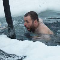 Scott Clifford takes a dip in a swimming hole prepared at the Casey research station on Tuesday as Antarctic researchers welcome the winter solstice and look forward to brighter days after weeks of darkness. Antarctic researchers mark winter solstice with icy plunge