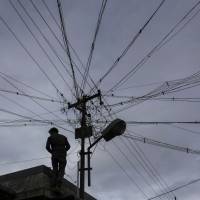 An electrician carries out work near a utility pole in Coonoor, in southern India’s Tamil Nadu state, on June 7. India speeds up environmental approval process for major industrial projects
