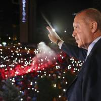 Turkey’s President Recep Tayyip Erdogan waves to supporters of his ruling Justice and Development Party in Ankara early Monday. Turkey's Recep Tayyip Erdogan celebrates poll triumph, opposition troubled