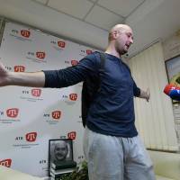 Anti-Kremlin journalist Arkady Babchenko speaks as he stands in front of a portrait of him that his colleagues displayed in his memory in the offices of his workplace, the ATR TV channel, on Thursday in Kiev a day following his shock reappearance after Ukrainian authorities said he had been shot dead. Makeup and pig's blood: Russian reporter describes his faked assassination in Kiev