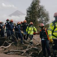 Firefighters carry skeletal remains found buried at a house during a search at an area affected by the eruption of the Fuego volcano at El Rodeo in Escuintla, Guatemala, Wednesday. Rescuers comb smoldering ash in search for 200 missing near Guatemala volcano as death toll hits 85