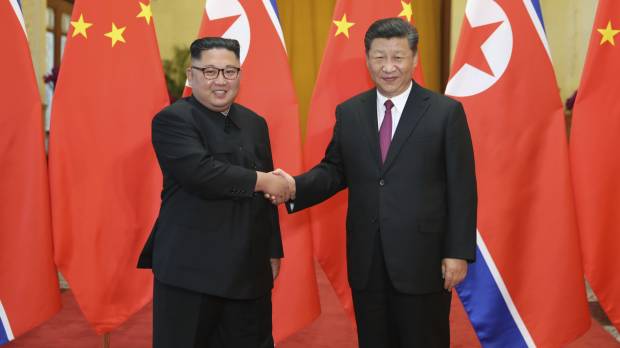 Chinese President Xi Jinping shakes hands with North Korean leader Kim Jong Un during a welcoming ceremony at the Great Hall of the People in Beijing on Tuesday. In talks with China's Xi, Kim reiterates call for step-by-step denuclearization process
