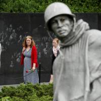 A woman carries a rose to the Korean War Veterans Memorial in Washington on Monday. Ten historic moments in U.S.-North Korean relations
