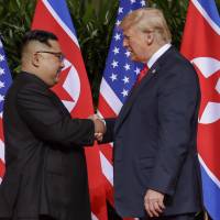 U.S. President Donald Trump shakes hands with North Korea leader Kim Jong Un at the Capella resort in Singapore on Tuesday. Trump sees shared path with North Korea's Kim after denuclearization summit