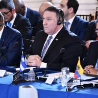 U.S. Secretary of State Mike Pompeo attends the Organization of American States (OAS) 48th General Assembly in the OAS Main Building in Washington Monday. At left is Grenada’s Permanent Representative to the OAS E. Angus Friday and at right is El Salvador’s Vice Foreign Minister Carlos Castaneda. The United States and six more of the most influential countries in the Organization of American States called Monday for the launch of procedings to suspend Venezuela from the body. U.S. renews call for OAS to suspend Venezuela over its 'full-scale dismantling' of democracy