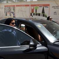 Saudi Majdoleen Mohammed Alateeq (right), a newly licensed Saudi driver, prepares for driving her car near her home in Riyadh Sunday. Saudi Arabia ended its longstanding ban on women driving on SundayJ — and the second the clock struck midnight, women across the country started their engines. Saudi women finally take to the wheel but with consent of male guardians
