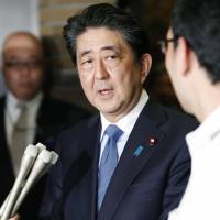 Prime Minister Shinzo Abe talks to reporters on Tuesday night after his conversation with U.S. President Donald Trump. Japan plans to settle North Korea abduction issue through direct talks with Kim