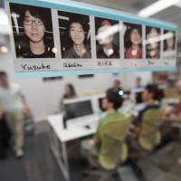 Portraits of students at Code Chrysalis, a software-coding boot camp, are seen on a window of a classroom in a basement room in Tokyo on May 23. Silicon Valley-style coding boot camp seeks to reset Japan Inc.