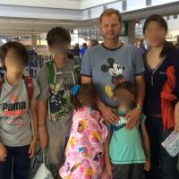 Long legal battle: James Cook is pictured with his estranged wife and their two pairs of twins. Left-behind dad's last resort: Impeach Japan's Supreme Court judges