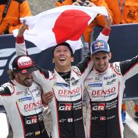 Toyota drivers Kazuki Nakajima (center) Fernando Alonso (left) and Sebastien Buemi celebrate after winning the 24 Hours of Le Mans on Sunday in Le Mans, France. Kazuki Nakajima helps lead 1-2 finish for Toyota in 24 Hours of Le Mans