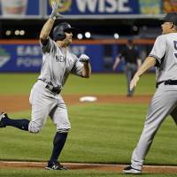 The Yankees’ Brett Gardner celebrates his two-run homer with third base coach Phil Nevin in the top of the eighth inning against the Mets on Friday night. Yankees top Mets in Subway Series opener; Masahiro Tanaka leaves game with pain in hamstrings