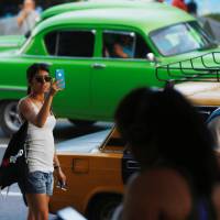 A woman uses the internet on her mobile phone at a hotspot in Havana July 10. Communist-run Cuba starts rolling out internet on mobile phones