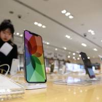 Apple iPhones are displayed at a SoftBank store in Tokyo. The Fair Trade Commission believes iPhone contracts in Japan may constitute a violation of antitrust regulations. Apple reviews iPhone contracts with Japan’s three major carriers after FTC raises antitrust concerns