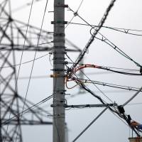 A worker repairs electric wires near Kepco’s Oi nuclear power station in Oi, Fukui Prefecture. Amid market liberalization, Kepco and Osaka Gas are locked in a struggle for dominance in the Kansai region’s power and gas markets. Regional gas and electric heavyweights Kepco and Osaka Gas slug it out in Kansai region battleground