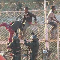 African migrants in this still image from video climb the border from Morocco to Spain’s North African enclave of Ceuta Thursday. Over 600 migrants rush the fence to enter Spain's North Africa enclave of Ceuta