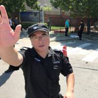 A security guard cautions a photographer following at blast outside the U.S. Embassy in Beijing on Thursday. U.S. Embassy in Beijing targeted by lone assailant with 'firework device'