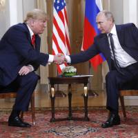 U.S. President Donald Trump and Russian President Vladimir Putin shake hands at the beginning of a meeting in Helsinki on Monday. Trump dismisses U.S. intelligence on Russia poll meddling, backs Putin denial after secretive summit