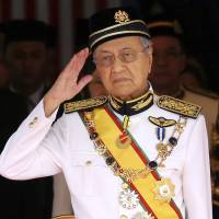 Malaysian Prime Minister Mahathir Mohamad salutes during the opening of the parliamentary session July 17 in Kuala Lumpur. Malaysian prime minister vows to repeal controversial security law