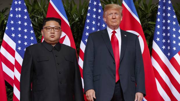 U.S. President Donald Trump stands with North Korean leader Kim Jong Un during a meeting on Sentosa Island, in Singapore on June 12. North Korea says it will grant large-scale prisoner amnesty next month