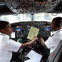Pilots sit in the cockpit as they prepare Ethiopian Airlines ET314 flight to Eritrea’s capital Asmara at the Bole International Airport in Addis Ababa Wednesday. Plane makers working on tech to cut cockpit crews to one but facing pilot pushback