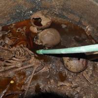 The skeletons of several mummies are seen at the site of the newly discovered giant black sarcophagus in Alexandria, Egypt, on Thursday. Thousands sign online petition to 'let people drink' reddish liquid found in 2,000-year-old Egyptian sarcophagus