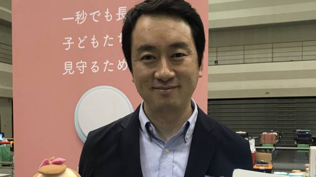 Unifa Inc. President Yasuyuki Toki shows off a tablet and a sensor, modelled using a doll, that can be used to monitor sleeping infants at nursery schools. Nagoya firm's high-tech service aims to prevent sudden infant death syndrome at nursery schools