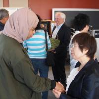 A woman shakes hands with hibakusha Keiko Ogura (right) at Harvard Kennedy School in Boston in May. Hiroshima hibakusha recounts experience to American university students