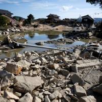 Houses that have been badly damaged or destroyed are seen on July 9 near the site where the banks of the Suemasa River in the Mabicho district of Kurashiki, Okayama Prefecture, broke. In Mabicho, delays, lack of awareness raised death toll from floods
