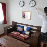 Clocks hanging on the wall of a room rented out to tourists in Naha show the time in Japan as well as that of the guests’ home country. Large percentage of private lodgings in Okinawa vanish after new <I>minpaku</I> law takes effect
