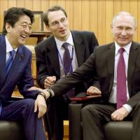Prime Minister Shinzo Abe and Russian President Vladimir Putin share a laugh at the Kodokan Judo Institute in Tokyo in December 2016. Trump-Putin summit: A political boon for Abe?