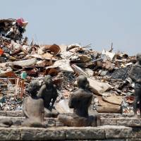 Household waste collected in the wake of the heavy flooding in western Japan is piled up at a temporary collection site in Kurashiki, Okayama Prefecture, on Saturday. West Japan rains to be designated 'extremely severe disaster' to increase state aid subsidies