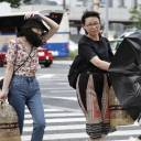 Women are buffeted by strong winds in Nagoya on Saturday afternoon as Typhoon Jongdari approached western Japan.