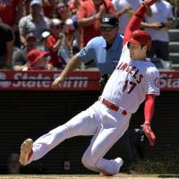 The Angels’ Shohei Ohtani slides home to score during the second inning of Los Angeles’ victory over the Astros on Sunday. Angels cruise to easy victory against Astros
