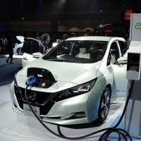 A new Leaf electric vehicle is connected to a charging station at its unveiling by Nissan Motor Co. in the city of Chiba in September 2017. Renault-Nissan-Mitsubishi and other carmakers have all channeled funds into battery companies. Battery technologies seen as new class of 'stranded assets' as innovation rushes ahead