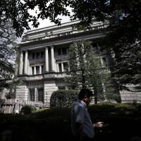 A man walks past the Bank of Japan headquarters in Tokyo. BOJ-watchers pare back expectations of future policy changes