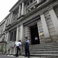 A security guard stands outside the Bank of Japan headquarters in Tokyo. Despite the central bank’s first policy tweak in almost two years, little seems to have changed for the nation’s insurers. Bank of Japan's threat to global bonds fizzles as Japanese insurers stay put