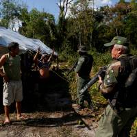 Agents of the Brazilian Institute for the Environment and Renewable Natural Resources, or Ibama, check a man at an illegal logging camp during “Operation Green Wave” to combat illegal logging in Apui, in the southern region of the state of Amazonas, Brazil, July 28. Illegal fishing, harm to Amazon forest linked to firms using tax havens: study