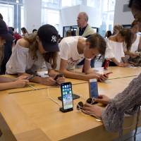Customers browse products in an Apple store in New York on Aug. 2. Apple Inc. is planning to unveil three new phones in September, sources said. Apple to expand iPhone X design with new colors, big screens