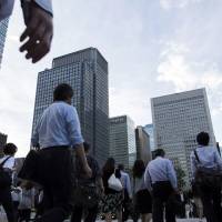 Commuters cross a road in the central business district of Tokyo on June 27. A poll shows most big and midsized Japanese firms favor a more open immigration system to offset the country’s labor shortage. Japan firms welcome skilled foreign workers; majority open to more open immigration system: poll