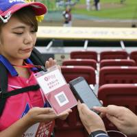 This handout photo provided by Rakuten shows how someone can use a smartphone and QR codes to buy refreshments. Payments via QR codes slowly becoming more widespread in Japan