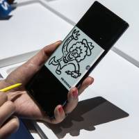 An attendee demonstrates a Samsung Electronics Co. Galaxy Note 9 S-Pen stylus on a Galaxy Note 9 smartphone during the Samsung Unpacked product launch event in New York on Thursday. Samsung's new $1,000 power-user phone reflects slowdown in hardware innovation