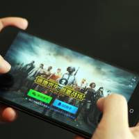 A mobile gamer plays Tencent’s multiplayer online game “PlayerUnknown’s Battlegrounds” on his smartphone in Ji’nan city, Shandong province, on March 16. Tencent operates the world’s largest games business by revenue thanks to its position in China, which according to data from consultancy Newzoo is the world’s top video-games market with an estimated revenue of $37.9 billion. 'Game over' in China as Beijing halts approvals of video game licenses