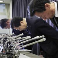 Yamato Holdings Co. President Masaki Yamauchi (center) and other executives apologize during a news conference Friday in Tokyo. Yamato admits it intentionally overcharged clients for moving services