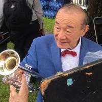 All that jazz: Trumpet player and singer Yoshio Toyama speaks with admirers in New Orleans. 'Japanese Satchmo' moved to tears after New Orleans honor